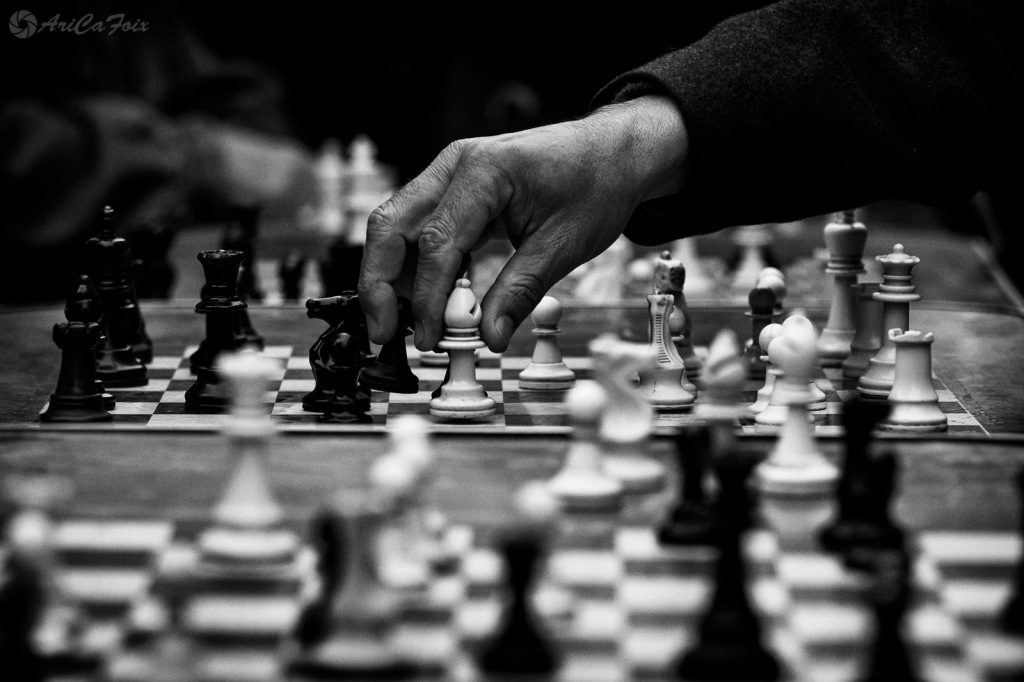 La mano de un ajedrecista roba una pieza sobre el tablero.