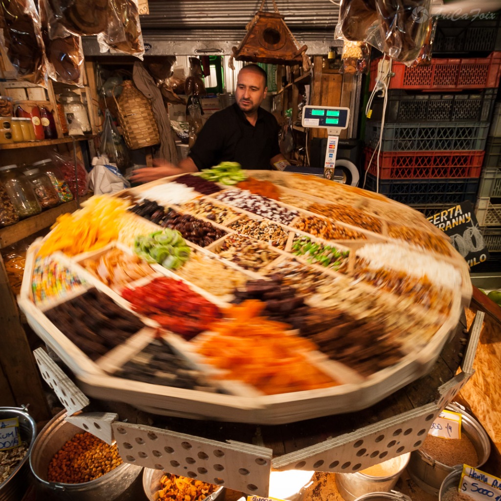 Un vendedor de frutos secos hace girar una mesa que parece ruleta en La Vega Central.